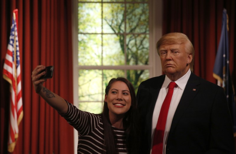 © Reuters. A woman poses with a waxwork of U.S. President-elect Donald Trump during a media event at Madame Tussauds  in London