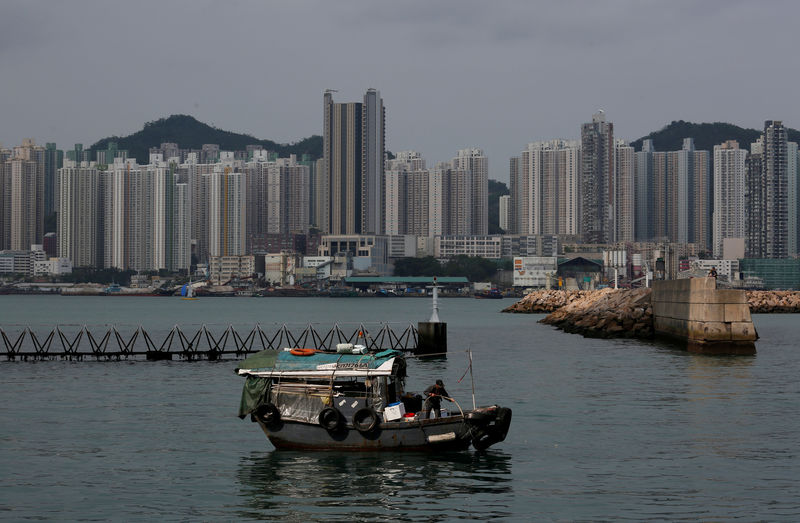© Reuters. FILE PHOTO: A boat sails in front of private and public housing blocks in Hong Kong