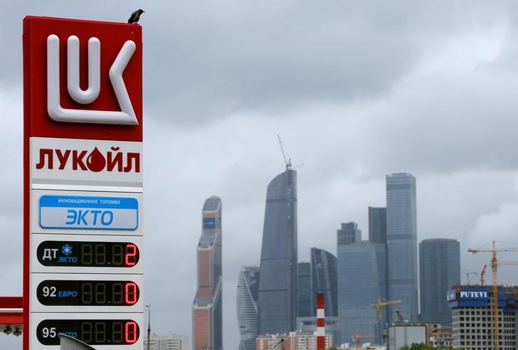© Reuters. Bird sits on price board at Lukoil petrol station in Moscow