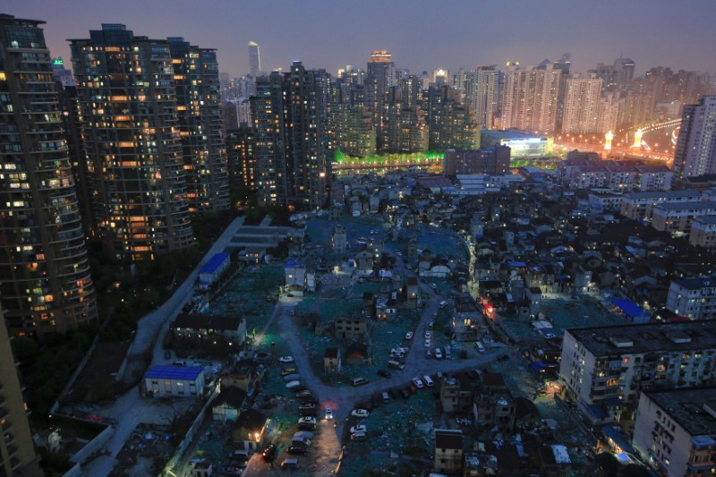 © Reuters. FILE PHOTO: A night view of the old houses surrounded by new apartment buildings at Guangfuli neighbourhood in Shanghai