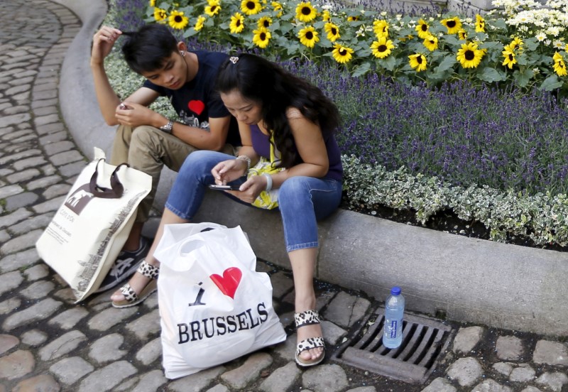 © Reuters. FILE PHOTO: Tourists take break in the decorated yard of Brussels' town hall