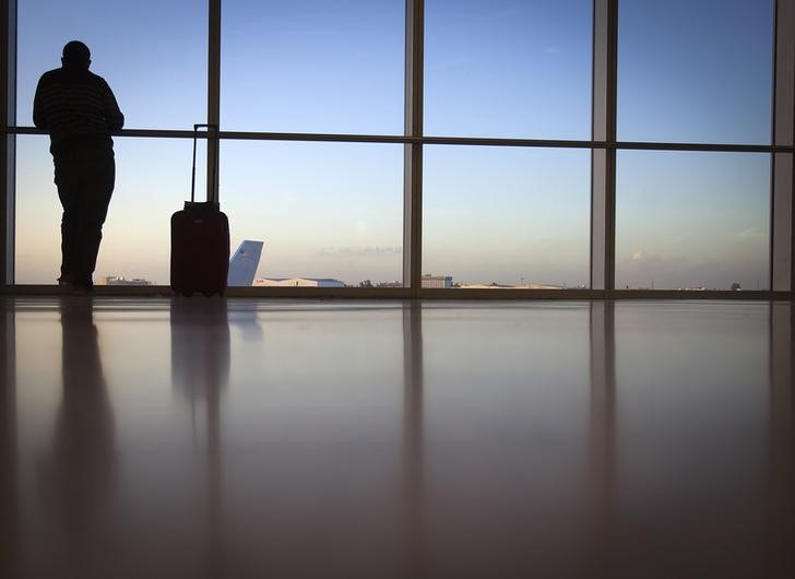 © Reuters. A passenger looks out the window at Miami International Airport in Miami