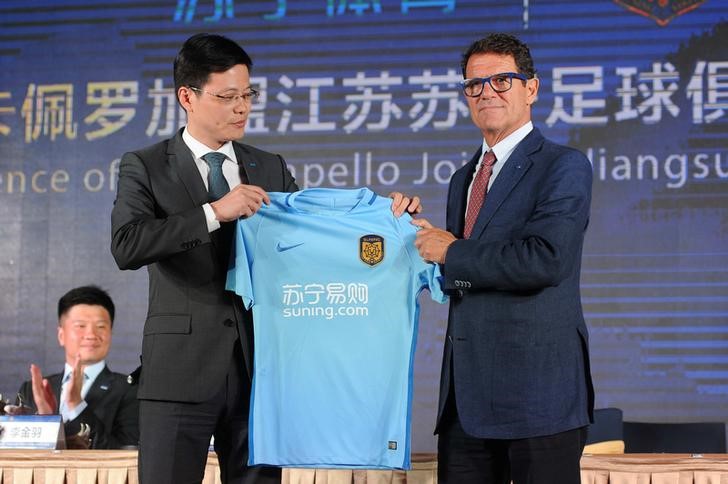 © Reuters. Fabio Capello, new head coach of Chinese Super League Jiangsu Suning club, poses for pictures with his team jersey during a news conference in Nanjing