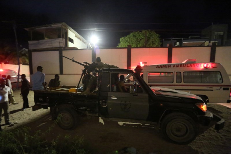 © Reuters. Armed security forces and rescue personnel are seen at the scene of an attack outside an hotel in Mogadishu