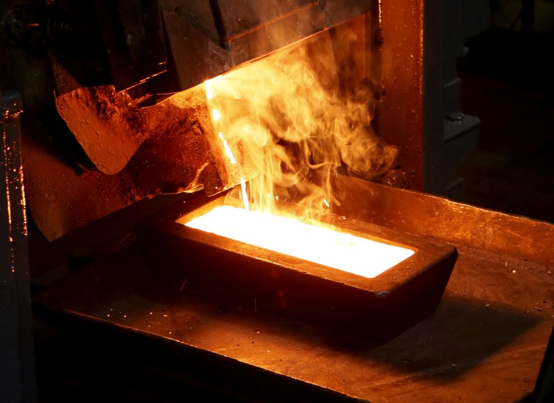 © Reuters. FILE PHOTO: A melter casts an ingot of 92.96 percent pure gold at a procession plant of the Olimpiada gold operation in Krasnoyarsk region