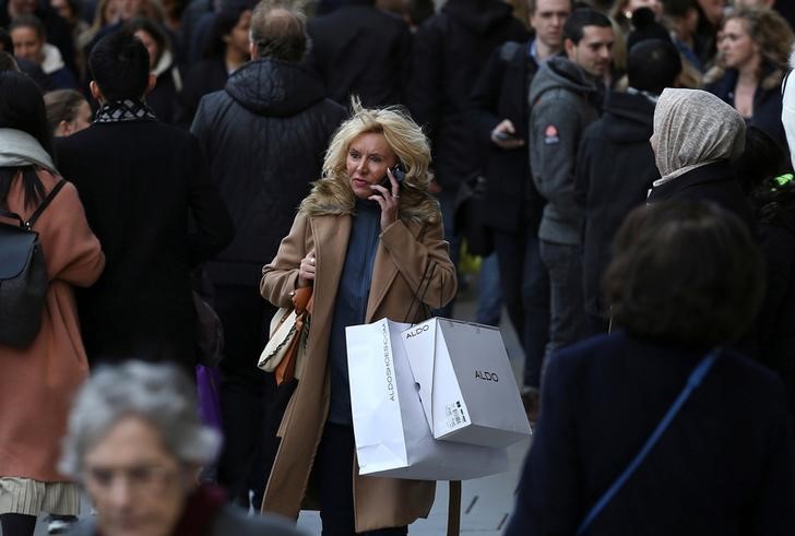 © Reuters. A shopper speaks on her mobile phone as she walks along Oxford Street in London