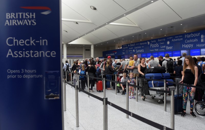 © Reuters. People queue with their luggage for the  British Airways check-in desk at Gatwick Airport in southern England