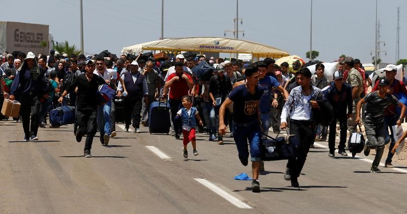 © Reuters. لاجئون سوريون في تركيا يعودون لوطنهم سيرا على الأقدام للاحتفال بعيد الفطر
