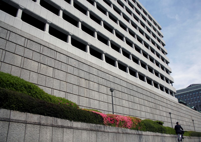 © Reuters. Man riding bicycle rides past the Bank of Japan building in Tokyo