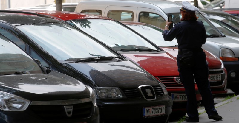 © Reuters. A traffic warden checks cars parked on a street in Vienna