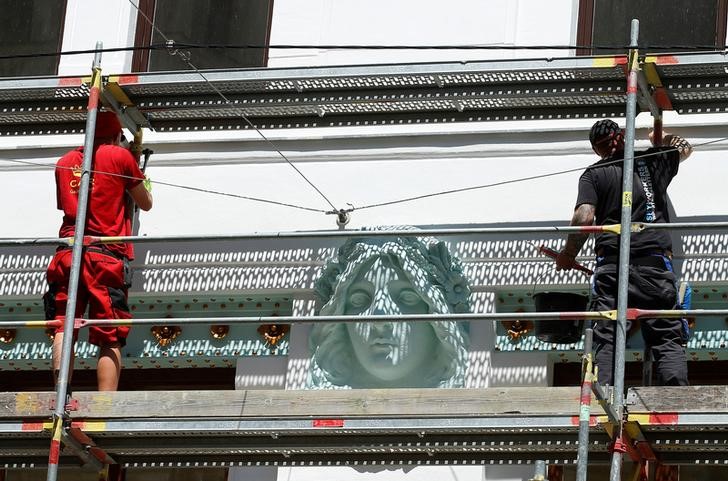 © Reuters. Workers dismantle a scaffolding on a bulding in central Vienna