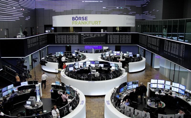 © Reuters. Traders work at their desks in front of the German share price index DAX board in Frankfurt