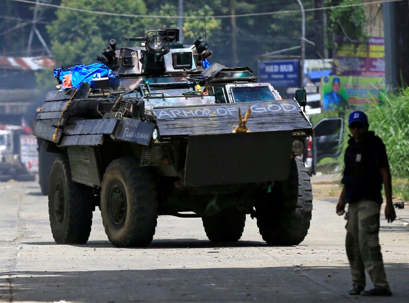 © Reuters. An armoured personnel carrier drives along the road in Marawi city