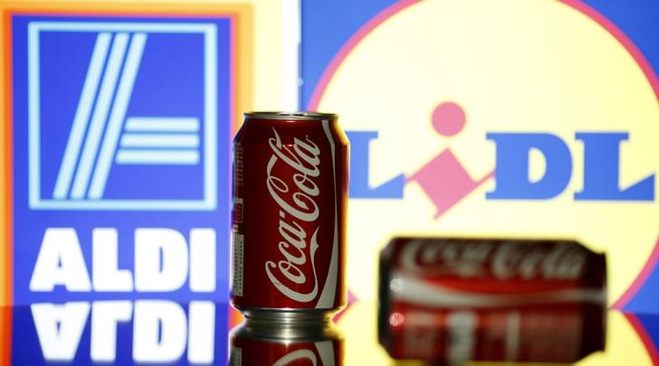 © Reuters. Picture illustration taken in Sarajevo shows a can of Coca-Cola in front of the logo of German multinational supermarket chain Lidl and Aldi