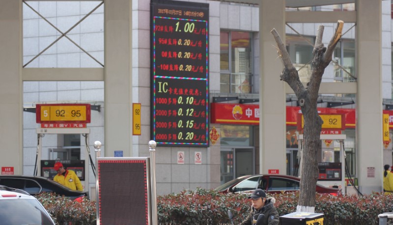 © Reuters. Discounts of gasoline prices are displayed at a CNPC gas station in Qingdao