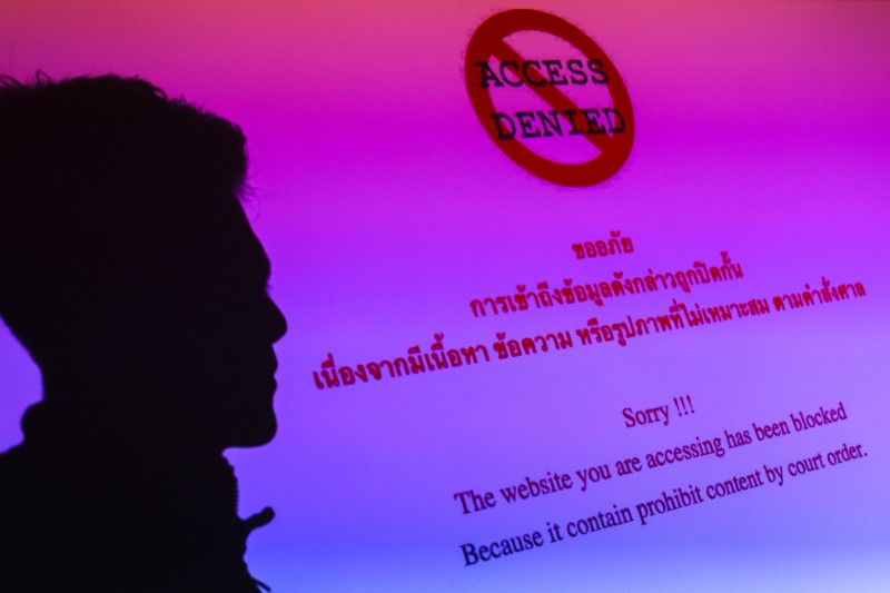 © Reuters. Illustration photo of a man silhouetted on an electronic screen displaying prohibited website in Bangkok