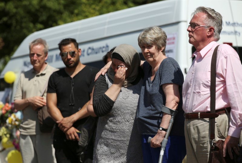 © Reuters. People attend a minute's silence for the victims of the Grenfell Tower fire near the site of the blaze in North Kensington, London