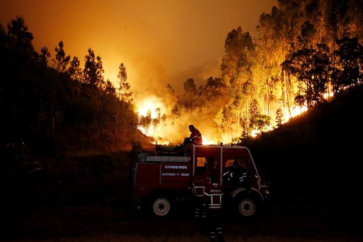 © Reuters. Bombeiros trabalham para apagar incêndio florestal perto de Bouca, no centro de Portugal