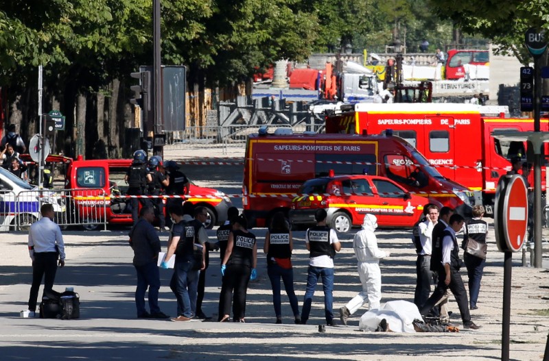 © Reuters. Polícia criminal inspeciona corpo de suspeito envolvido em incidente na avenida Champs-Élysées, em Paris