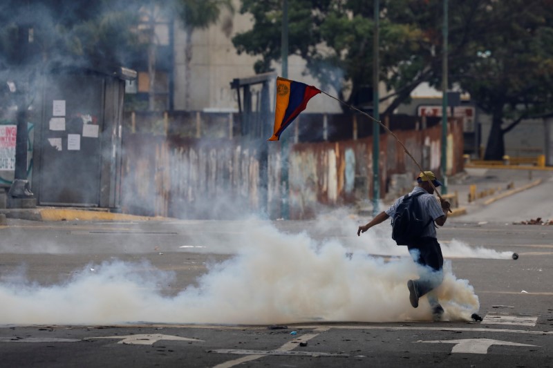 © Reuters. Manifestante chuta granada de gás lacrimogêneo durante manifestação contra o governo de Nicolas Maduro,  em Caracas