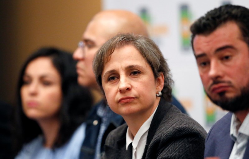 © Reuters. Mexican journalist Carmen Aristegui listens beside activists, human-rights lawyers and journalists during a news conference in Mexico City