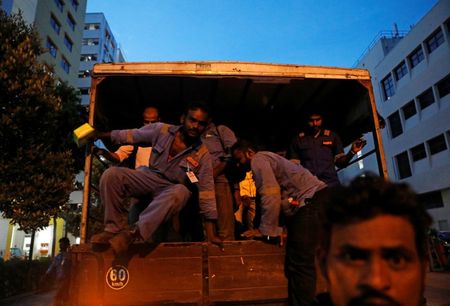 © Reuters. Migrant shipyard workers return to their dormitories in a lorry after a day's work in Singapore