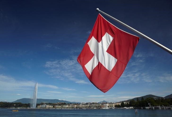 © Reuters. Swiss flag is pictured next to Jet d'Eau and Lake Leman from the St-Pierre Cathedrale in Geneva