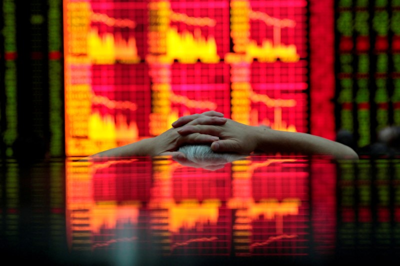 © Reuters. FILE PHOTO: A man looks at an electronic board at a brokerage house in Shanghai