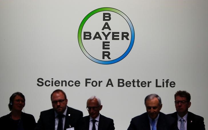 © Reuters. Members of the supervisory board of German pharmaceutical and chemical maker Bayer AG are silhouetted against the company's logo at the annual general shareholders meeting in Bonn