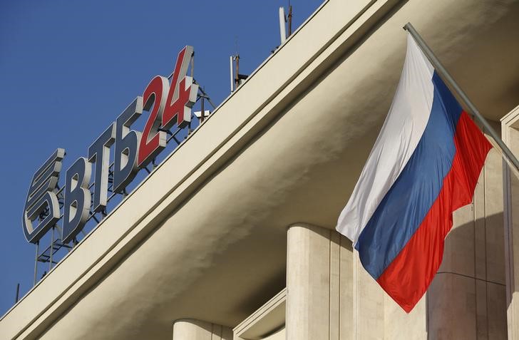 © Reuters. The logo of VTB Bank is displayed on the roof of a building, with a Russian national flag seen nearby, in Moscow