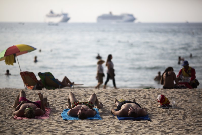 © Reuters. Tourists are seen at Patong beach which was badly hit by 2004 tsunami in Phuket, one of Asia's premier resort islands