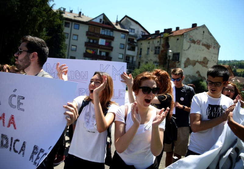 © Reuters. Bosnian high school students hold placards during a protest against segregation at schools in Travnik