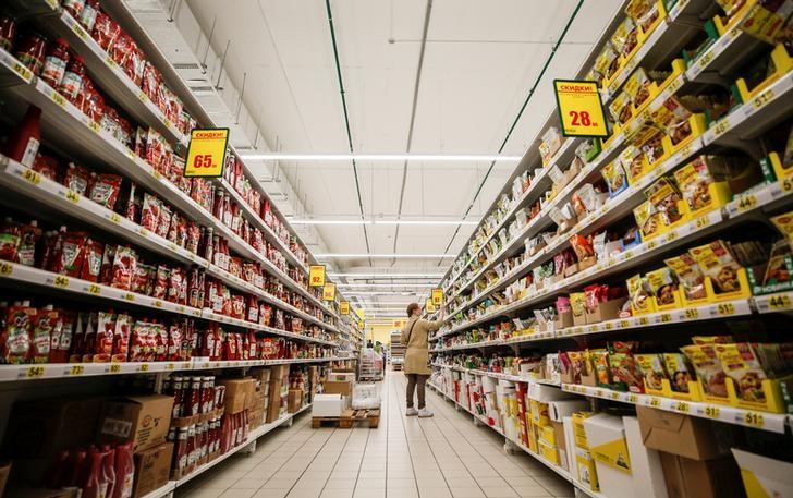 © Reuters. A woman browses aisles in Auchan hypermarket in Moscow