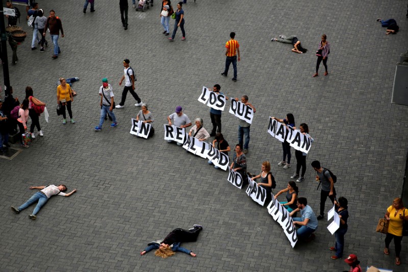 © Reuters. Opposition supporters hold letters to build a banner that reads "Those who kill in reality they have not lived" during a rally against Venezuelan President Nicolas Maduro's government in Caracas,