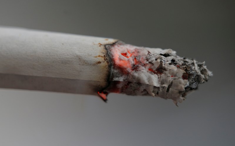 © Reuters. FILE PHOTO: A cigarette burns as an office worker takes a break in Sydney