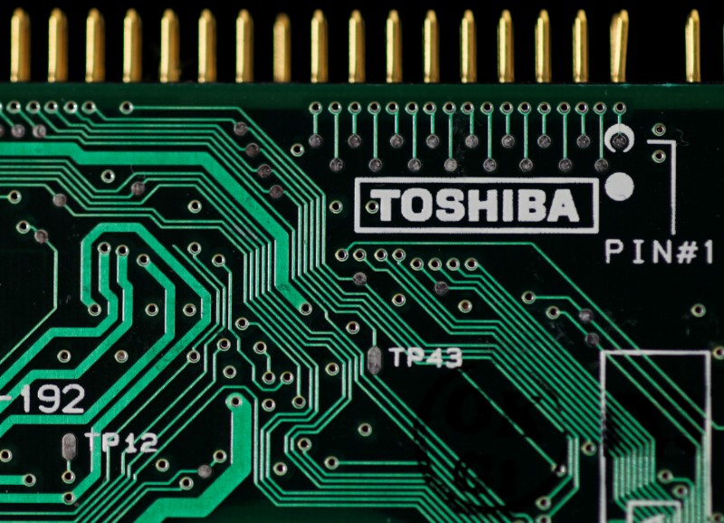 © Reuters. FILE PHOTO - A logo of Toshiba is seen on a printed circuit board in this photo illustration taken in Tokyo