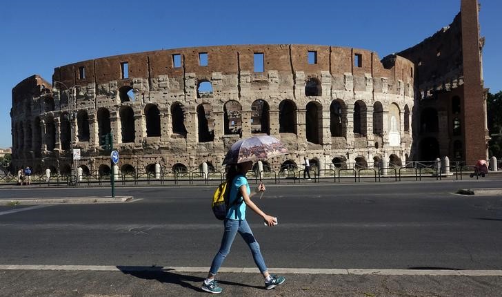 © Reuters. Foto de archivo de una mujer caminando por delante del Coliseo de Roma