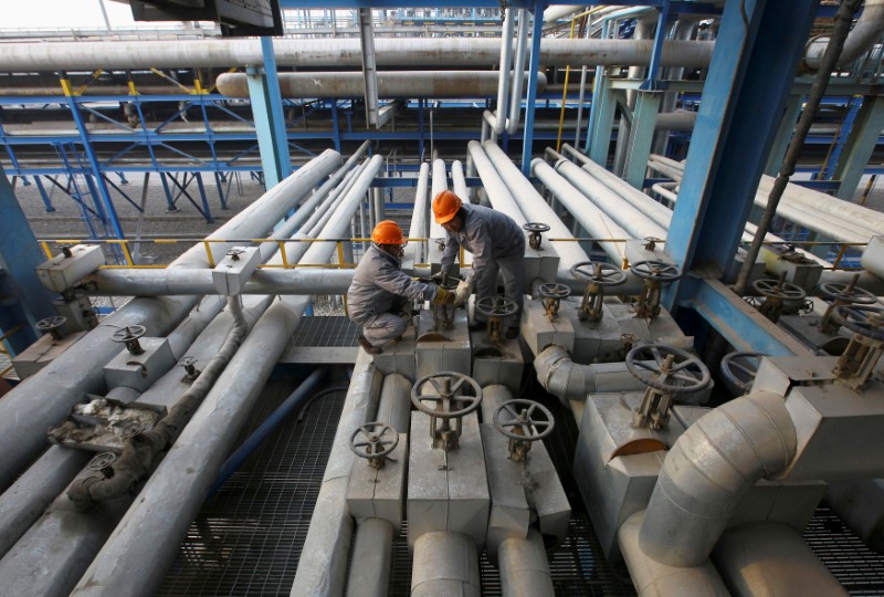© Reuters. FILE PHOTO: Employees close a valve of a pipe at a PetroChina refinery in Lanzhou, Gansu province