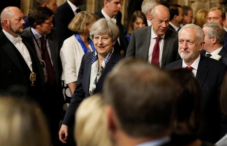 © Reuters. Britain's Prime Minister, Theresa May and opposition Labour Party leader Jeremy Corbyn, walk through the Peers Lobby in the Houses of Parliament during the State Opening of Parliament in central London