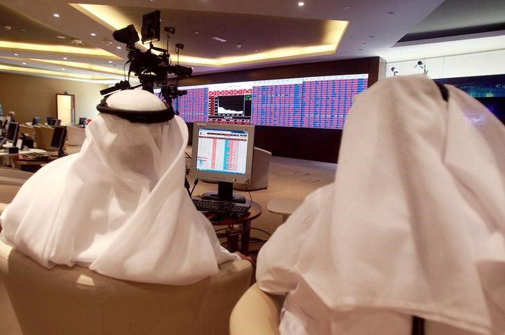 © Reuters. Traders monitor screens displaying stock information at Qatar Stock Exchange in Doha