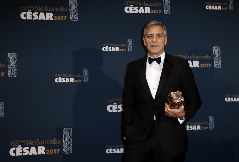 © Reuters. Actor George Clooney holds his trophy during a photocall after receiving an Honorary Cesar Award at the 42nd Cesar Awards ceremony in Paris
