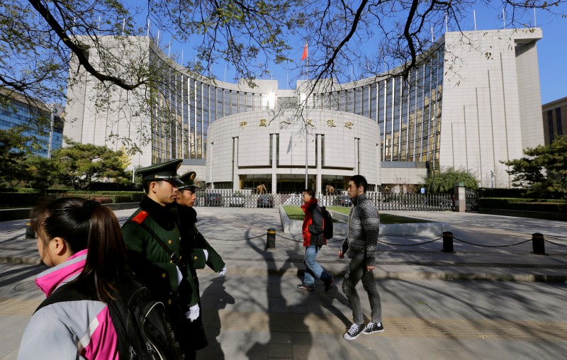 © Reuters. FILE PHOTO: People walk past PBOC headquarters in Beijing