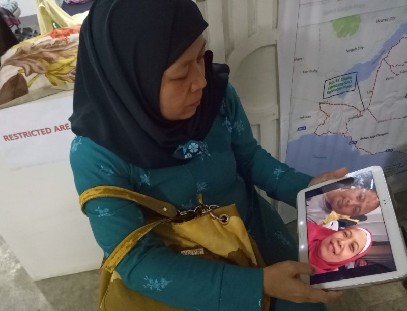 © Reuters. Carmalia Baunto shows an image of herself and her husband, Nixon Baunto, who is trapped inside the besieged town of Marawi City