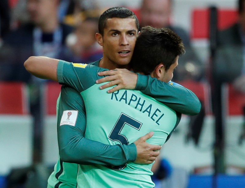 © Reuters. Los portugueses Cristiano Ronaldo y Raphael Guerreiro celebran el gol que dio la victoria a su selección sobre Rusia en la Copa Confederaciones, en el partido disputado en el Spartak Stadium de Moscú.