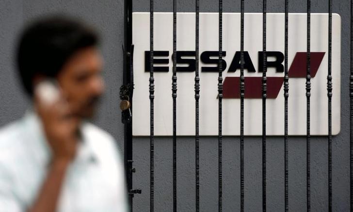 © Reuters. Мужчина на фоне логотипа Essar в Мумбаи