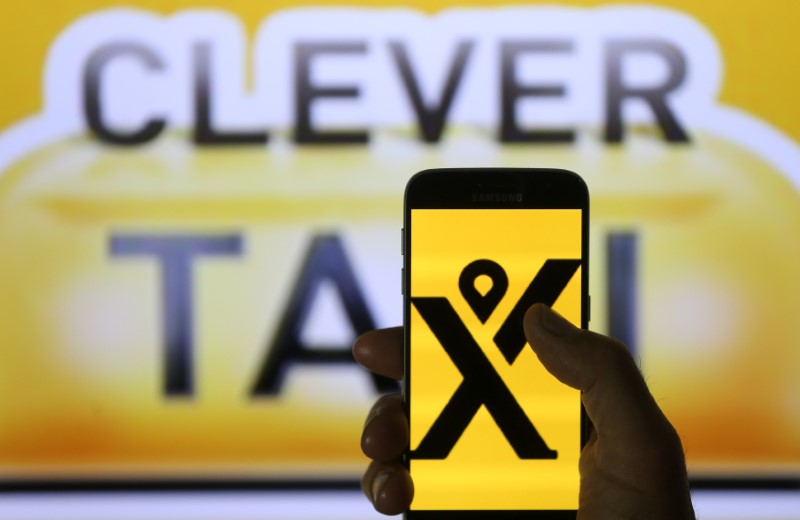 © Reuters. My Taxi logo are seen on the smartphone in front of displayed Cleaver Taxi logo in this illustration