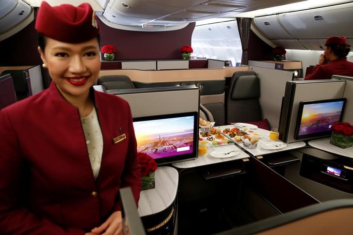© Reuters. A Qatar Airways crew member presents the business class seats of an Boeing 777 aircraft during the 52nd Paris Air Show at Le Bourget airport near Paris