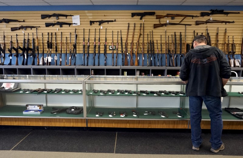 © Reuters. FILE PHOTO: A customer looks over weapons for sale at the Pony Express Firearms shop in Parker