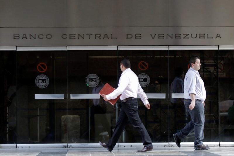 © Reuters. People walk past an entrance of the Venezuela's Central Bank in Caracas