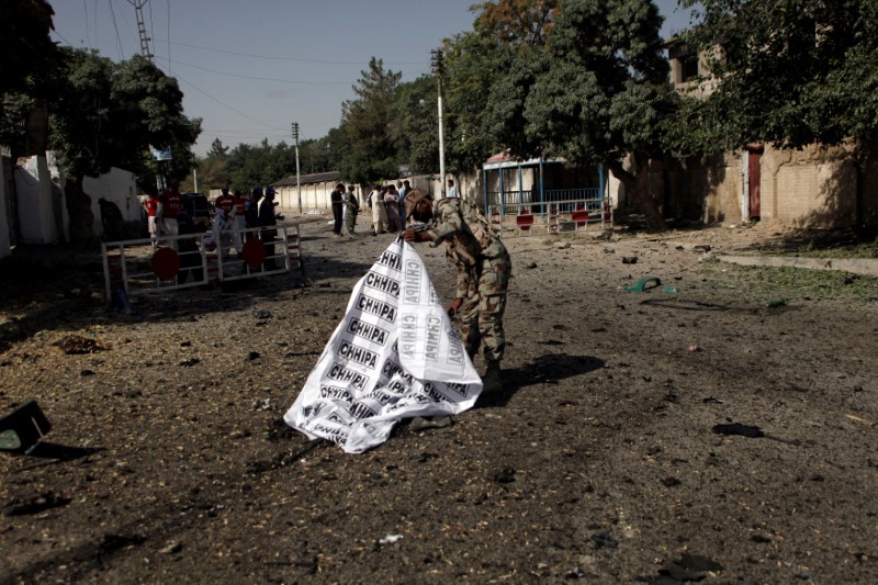 © Reuters. A soldier covers a body after a blast in Quetta